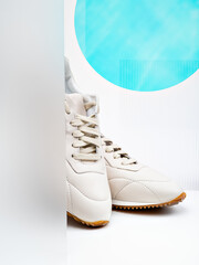 Comfortable, classic and modern. A white pair of glamorous female footwear. A photo with a white background, geometric minimal design and a blue emphasis. A concept of healthy living and urban style.
