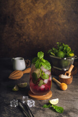 Fresh strawberry summer mojito cocktail with strawberry, lime, mint, rum and ice cubes.