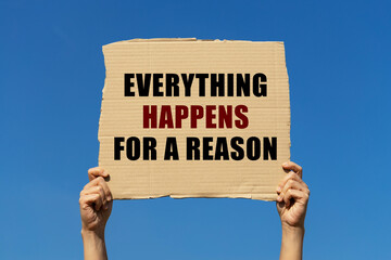 Everything happens for a reason text on box paper held by 2 hands with isolated blue sky background. This message board can be used as business concept about everything happens for a reason.