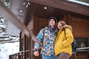 Fototapeta na wymiar Winter Outdoor Fun. Happy Cheerful Young Couple Throwing tube, ski, Having Fun During Winter Date At Camping, Enjoying Spending Holidays Together