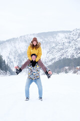 Winter Outdoor Fun. Happy Cheerful Young Couple Throwing tube, ski, Having Fun During Winter Date At Camping, Enjoying Spending Holidays Together