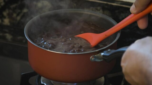 Preparing a pot of black beans on the stove at home. Feijoada.