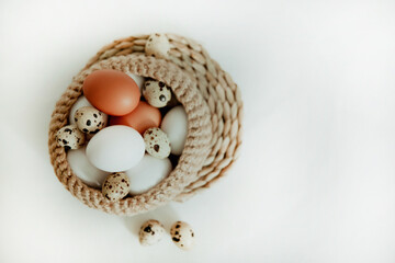 Obraz na płótnie Canvas Easter white and brown eggs in a basket with flowers on a white background