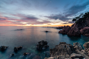 Magic sunrise at the rocky coastline of the sea.