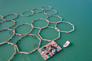 Fototapeta na wymiar Fish farm for breeding cages for trout and salmon. Concept aquaculture pisciculture, aerial top view