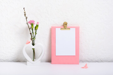 Message board mockup with creative plaster heart shape vase with flowers and butterflies