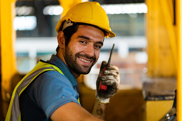 A handsome train driver uses a walkie-talkie or walkie-talkie in the interior room to control the train. Professional railway engineer.