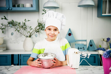 little cute funny smiling boy wearing a white chef's hat and uniform with white foam on his cheeks...