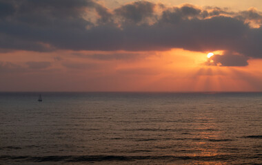 Fototapeta na wymiar Sea panorama. Sailboat goes on the waves during sunset