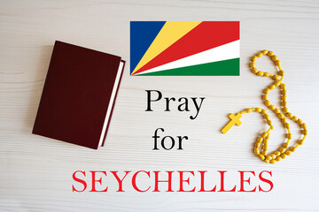 Pray for Seychelles. Rosary and Holy Bible background.