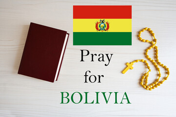 Pray for Bolivia. Rosary and Holy Bible background.