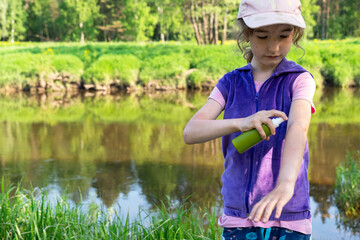 Girl uses a remedy for mosquitoes and biting insects in nature. Protection of the skin from tick bites, gadflies, blood-sucking pests, a means for children without allergens for outdoor camping