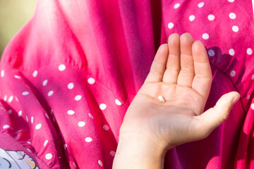 A girl holds a baby tooth that has fallen out in the palm of her hand. The child's teeth change to the molars, preschool age