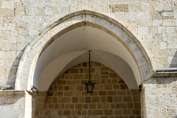 Arch, cross vaulted passage and outdoor antique pendant lamp with stone wall on the background in St. Paul's Church in Antakya, Hatay before 2023 Turkey–Syria earthquake. 