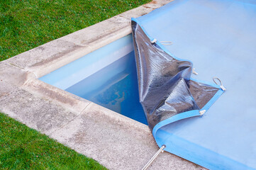 Garden pool is closed with a protective canvas when autumn arrives and prevents water evaporation...