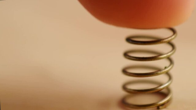 Close up of hand taking a metal spring on wooden surface