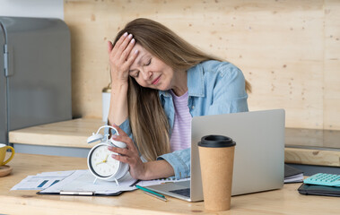 Despaired woman sitting at desk in office surrounded by paperwork, Work Life balance, work lif balance concept