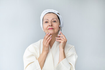 Portrait of gorgeous happy mature woman, senior older 60 year lady looking at camera touching her face