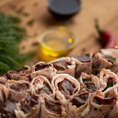 Liver shish kebab wrapped in lard on skewers. Raw kebab lies on table with spices, vegetables and herbs. Azerbaijani cuisine. Eastern cuisine. Top view. Close-up.
