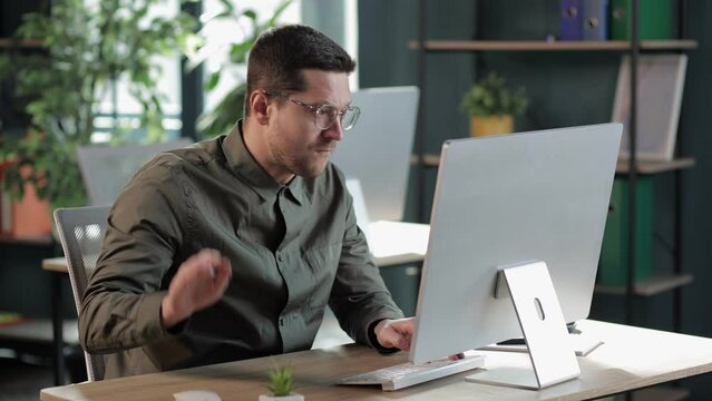 irritated Man in office working with pc Punches Table In Anger with fist. The end of patience. It is impossible to bear it. An attack of anger, stress.