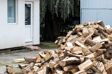 A pile of firewood for heating in winter in the yard of the farm