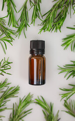 fragrant medicinal evergreen rosemary on a light background with a transparent glass and a jar of hair oil. medical plant rosemary for stress anxiety and more