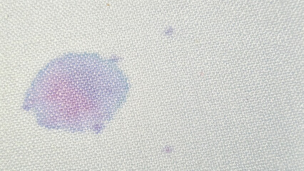 Gota de vino en un mantel, círculo púrpura sobre textura