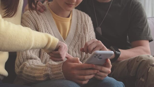 Cropped shot of modern parents helping their 11 year old daughter with new smartphone exploitation