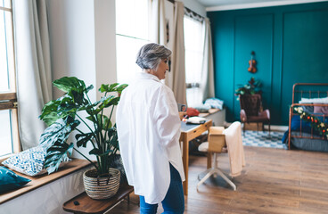 Fototapeta na wymiar Middle aged woman standing in modern living room
