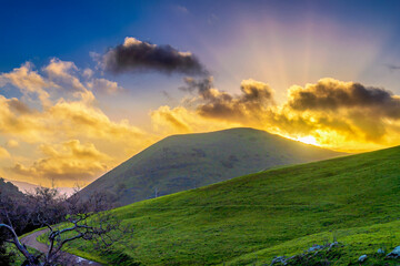 Sun rays over hill and sunset, sunrise in spring