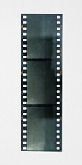 underexposed 35mm film strip on white paper background with deep scratch and empty frames, film material.