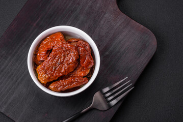 Delicious sun dried tomatoes in oil in a white ceramic bowl