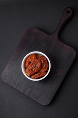 Delicious sun dried tomatoes in oil in a white ceramic bowl