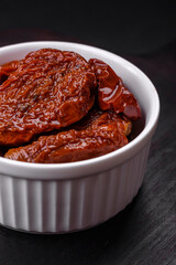 Delicious sun dried tomatoes in oil in a white ceramic bowl