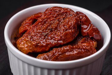 Delicious sun dried tomatoes in oil in a white ceramic bowl