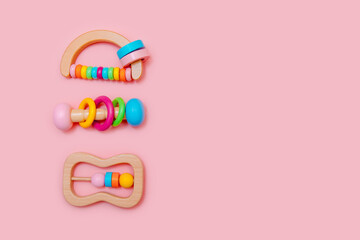 Cute set of wooden rattles. Eco-friendly toys for newborns in the colors of the rainbow. Flat lay, copy space.