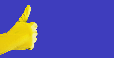 Thumb up gesture of hand in yellow glove on blue banner background with copy space for text