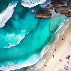 Aerial, drone photography view of clear blue water, beach, sand, and waves on a sunny day.