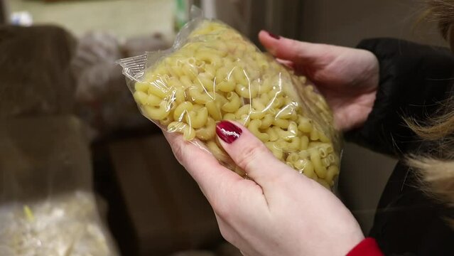 Customer chooses pasta in a cheap grocery store