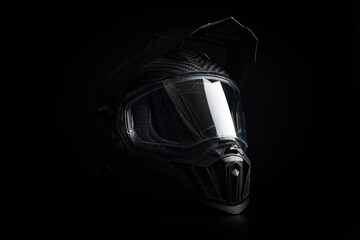 Black carbon motorcycle helmet. Offroad motocross helmet with shieldon black background.