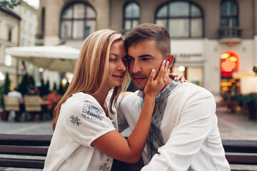 Naklejka premium Loving couple relaxing in old Lviv city wearing traditional national ukrainian shirts. Newlyweds spend time together