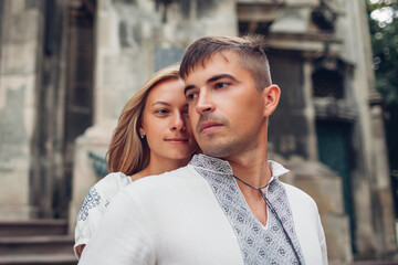 Man and woman in love walking in old Lviv city wearing traditional ukrainian shirts. Couple enjoy architecture