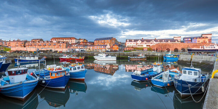 A lovely still morning with the colourful boats reflected in the harbour at Seahouses on the Northumberland coast, England