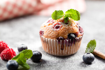 Freshly baked muffins with powdered sugar and fresh berries