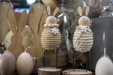 Playful Easter bunnies made of cotton thread with wooden heads and ears, with metal legs, on a...