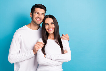 Photo portrait of cute young man woman embrace look interested empty space dressed stylish white garment isolated on blue color background