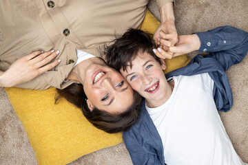 Portrait of happy woman with son, mother and boyfriend smiling and looking at camera lying together...