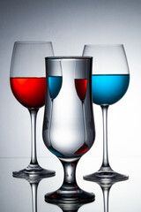studio photography, crystal glasses with colored liquids in mirrors