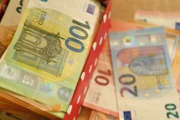 close-up box with family savings, cash 50, 20 euro banknotes on table, concept gift for holiday,...