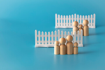 Behind withe fence family concept. Isolate wood figures on blue background.